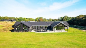 A modern house with a large patio area, a swimming pool, and a view of the surrounding landscape. - 5 Star Holiday Home in Sydals (Sydals)