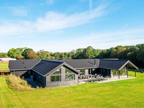 A modern building with multiple rooms and a covered outdoor area with seating. - 5 Star Holiday Home in Sydals (Sydals)