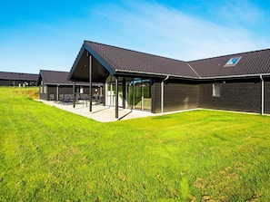 Een modern gebouw met een plat dak, grote ramen en een overdekt terras.