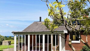 A house with a covered porch, a chimney, and a view of the landscape. - 6 Person Holiday Home in Augustenborg (Augustenborg)