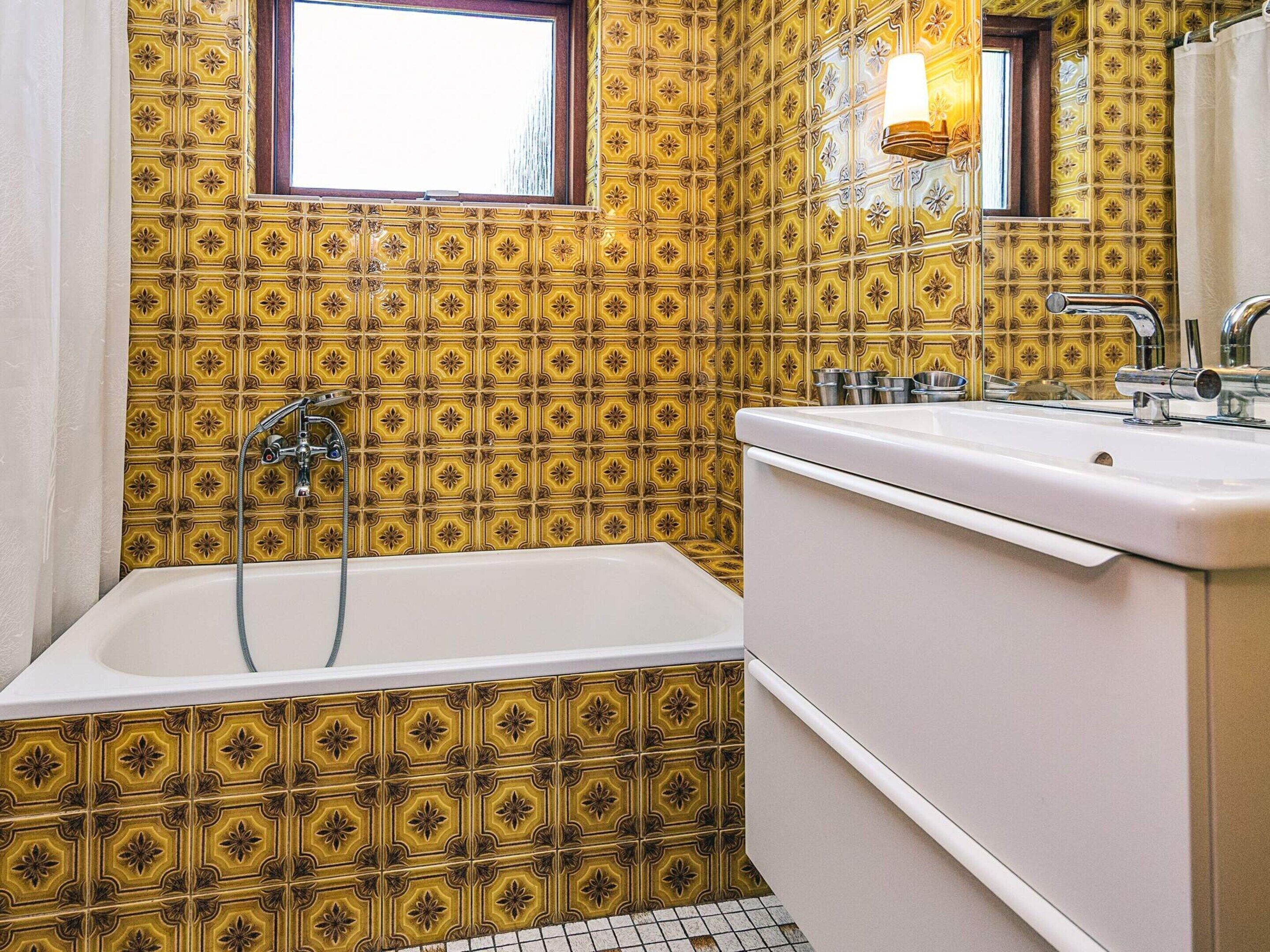 Une salle de bain avec une baignoire, un lavabo et un miroir.