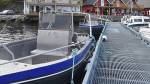 A dock with boats, a pier, and buildings in the background.