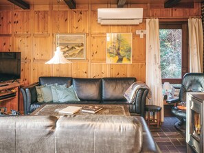 A cozy living room with a leather sofa, a coffee table, and a fireplace. - 4 Person Holiday Home in Blavand (Blavand)