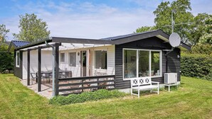 A modern mobile home with a patio area, large windows, and a satellite dish. - 6 Person Holiday Home in Allinge (Allinge)