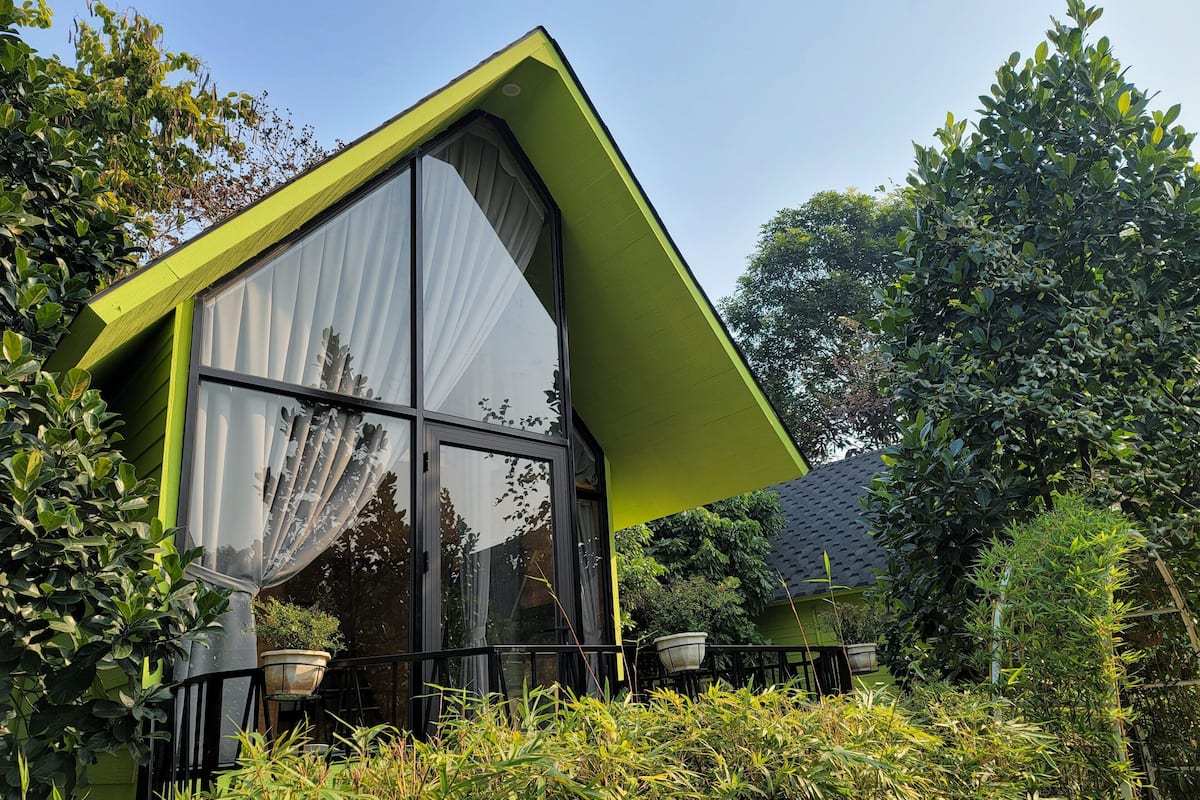 A modern house with a large glass window and a green roof.