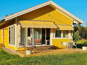 A yellow building with a covered patio, large windows, and outdoor seating. - 4 Star Holiday Home in Ljusdal (Ljusdal)