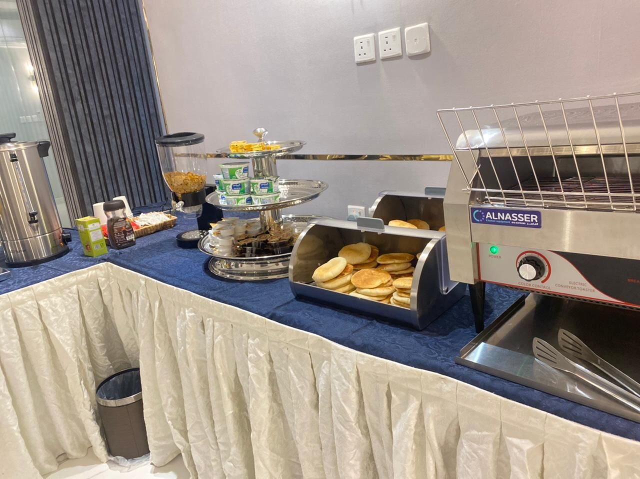 Una mesa de buffet con diferentes alimentos y un horno tostador.