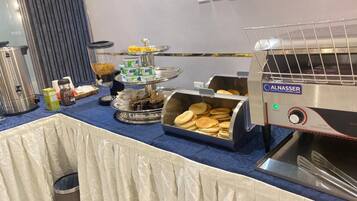Una mesa de buffet con diferentes alimentos y un horno tostador.