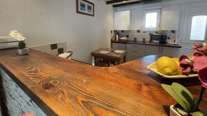 A modern kitchen with wooden countertops, a dining table, and a small island with a plant. - 3-room apartment for 4 in Châtelaillon-Plage with parking (Châtelaillon-Plage)