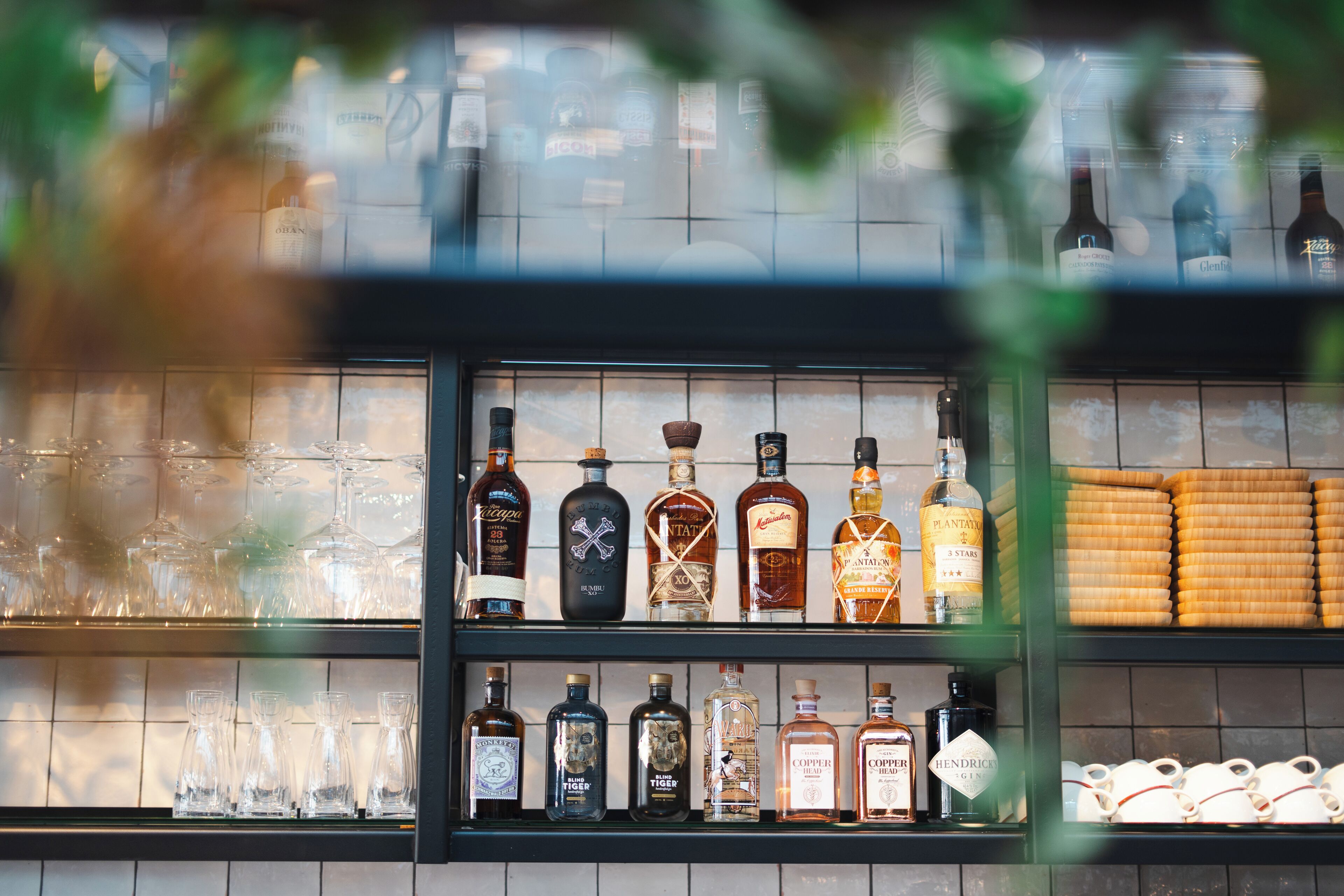 A bar with shelves of liquor bottles and glasses.
