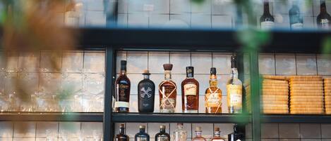 Un bar con estantes llenos de botellas de licores y vasos.