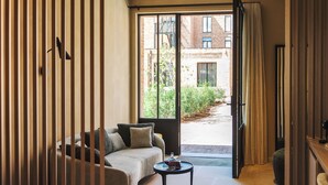 Una sala de estar moderna con sofá, mesa de centro y puerta corrediza de vidrio que da a un área exterior.