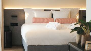 A modern bedroom with a bed, bedside tables, and a nightstand.