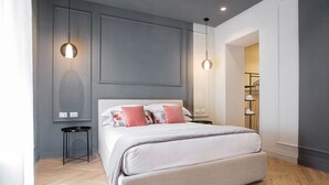 A modern bedroom with a large bed, two bedside tables, and pendant lighting. - The Couper Colonna (Rome)