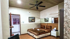 A hotel room with a bed, bedside table, chair, and a dining table with a chair. - OYO 767 Hotel Urban - Khotel Kurban Hotel (Baguio)