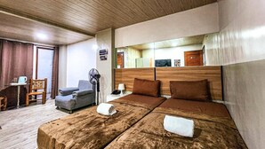 A hotel room with a large bed, a chair, a desk, and a fan. - OYO 767 Hotel Urban - Khotel Kurban Hotel (Baguio)
