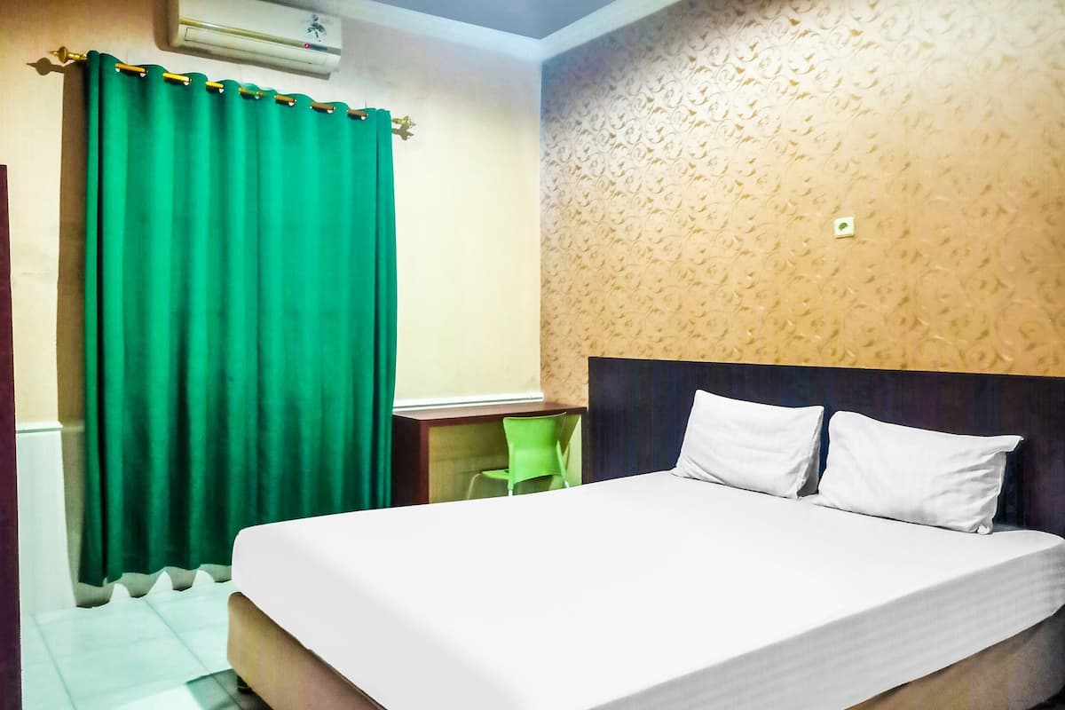 Ein Hotelzimmer mit Bett, Schreibtisch und Stuhl.