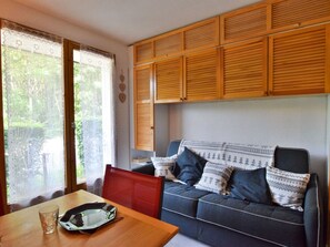 Una sala acogedora con sofá, una mesa de comedor y armarios de madera.