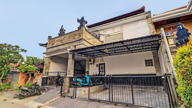 Una casa de dos pisos con un porche cubierto y una entrada protegida por un portón.