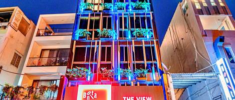 A hotel with a modern facade, balconies with plants, and a sign for 'The View' hotel.