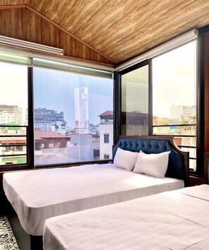 A hotel room with two beds, large windows, and a view of the cityscape. - Hanoi Hidden Guest House (Hanoi)