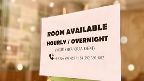 Een bord dat aangeeft of kamers beschikbaar zijn voor uren of overnachtingen.