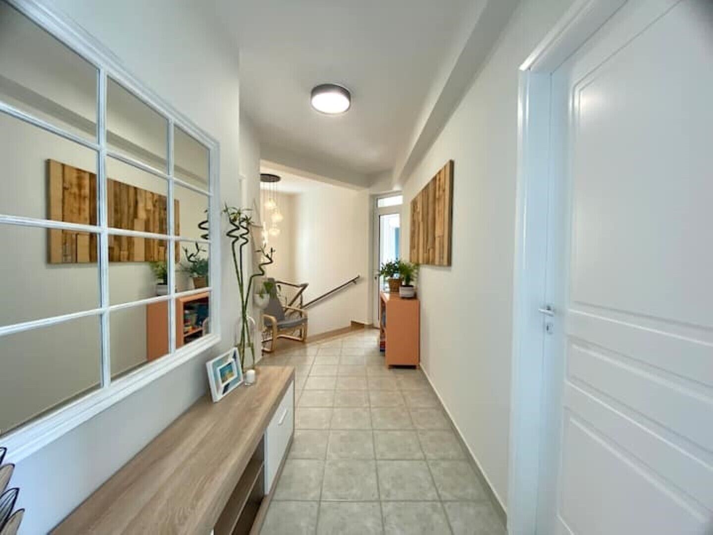 A hallway with a bench, a chair, and a door.
