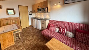 A compact living space with a kitchenette, a dining area, and a sofa. - Les Saisies Apt, 4 pers, south balcony, near slopes (Les Saisies)