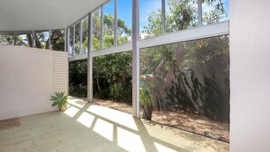 A room with large windows, a wooden floor, and a potted plant. - The Sanctuary - a tranquil hidden oasis (Hawks Nest)