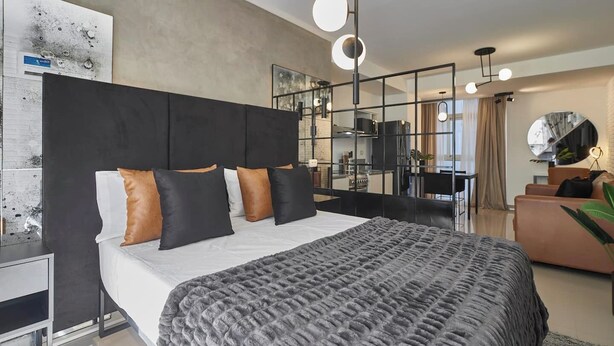 Un dormitorio moderno con una cama grande, un cabecero y una mesita de noche.