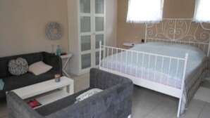 Une chambre à coucher comprenant un lit, un canapé, une petite table et une armoire.