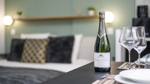 A bottle of champagne and two glasses on a table in a hotel room.