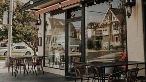 Un restaurant appelé « Acoma Fine Dining », doté d’une terrasse et d’une façade en verre.