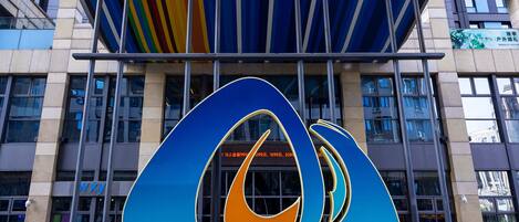 Um edifício moderno com uma grande marquise colorida e um logotipo marcante.