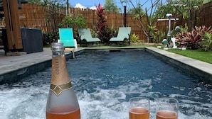 A bottle of Collet champagne and two glasses on a wooden table by a swimming pool. - Belle Villa Avec Piscine à 200m de la Plage ! (Saint-Leu)