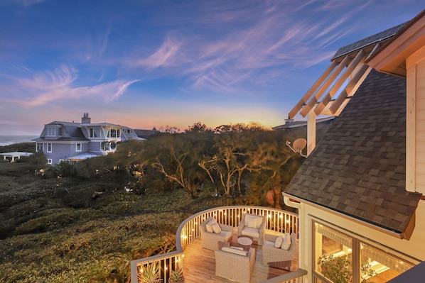 A house with a deck featuring outdoor furniture and a view of the surrounding landscape.