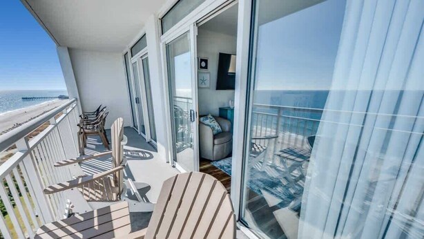 A balcony with a view of the sea, a chair, and a sofa. - King Suite 3BR,Direct Oceanfront Views, Remodeled! (Myrtle Beach)