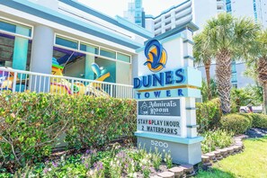 A sign for Dunes Tower with amenities including a restaurant, waterparks, and a stay & play option. - Newly Remodeled,Dunes Village 2BR,Indoor Waterpark (Myrtle Beach)