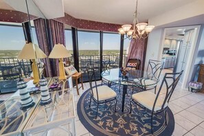 Une pièce avec une table en verre, des chaises et une vue sur le paysage.