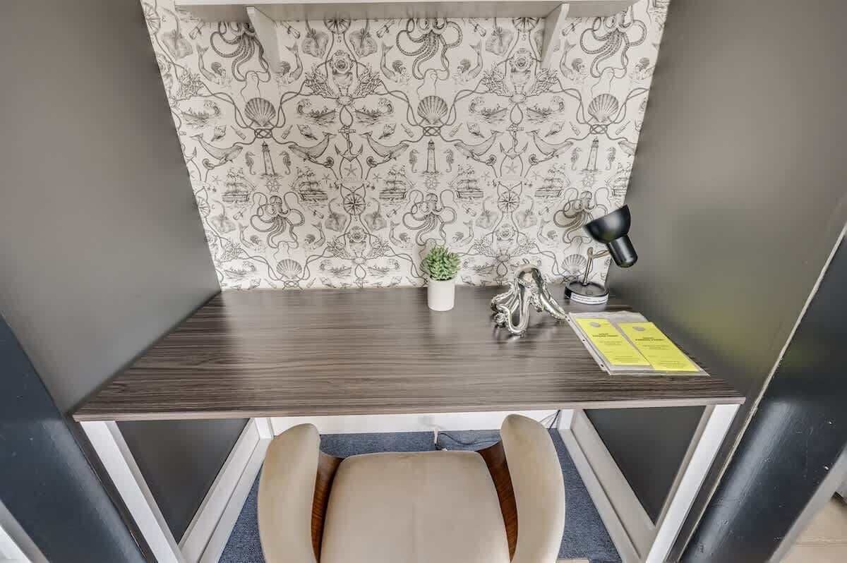 A compact workspace with a desk, chair, and a small potted plant.