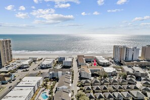Enjoy stunning ocean views from this beachfront hotel, featuring a mix of high-rise and single-story buildings, a swimming pool, and lush green spaces.