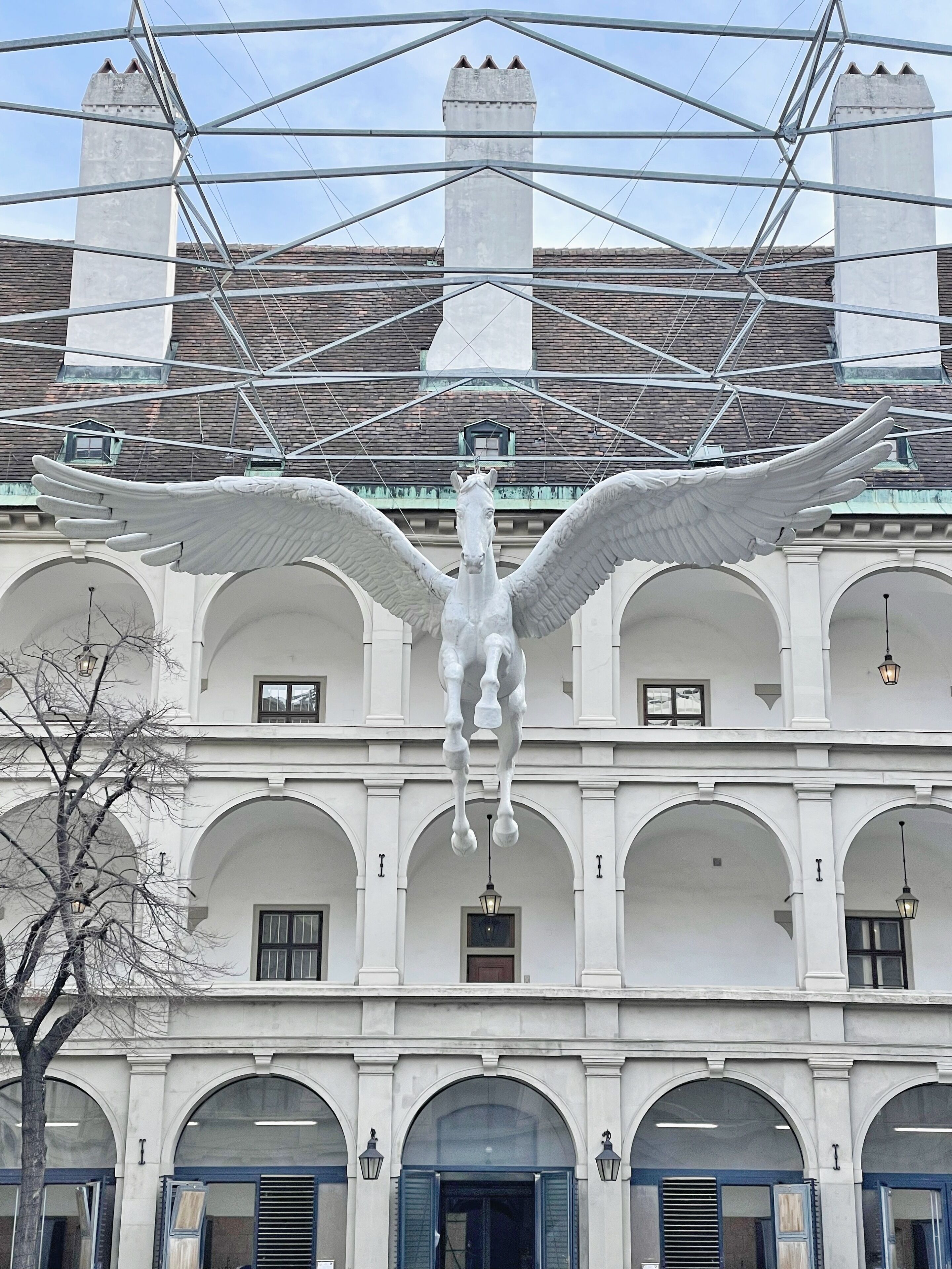 A building with a large white statue of a winged horse on the facade.