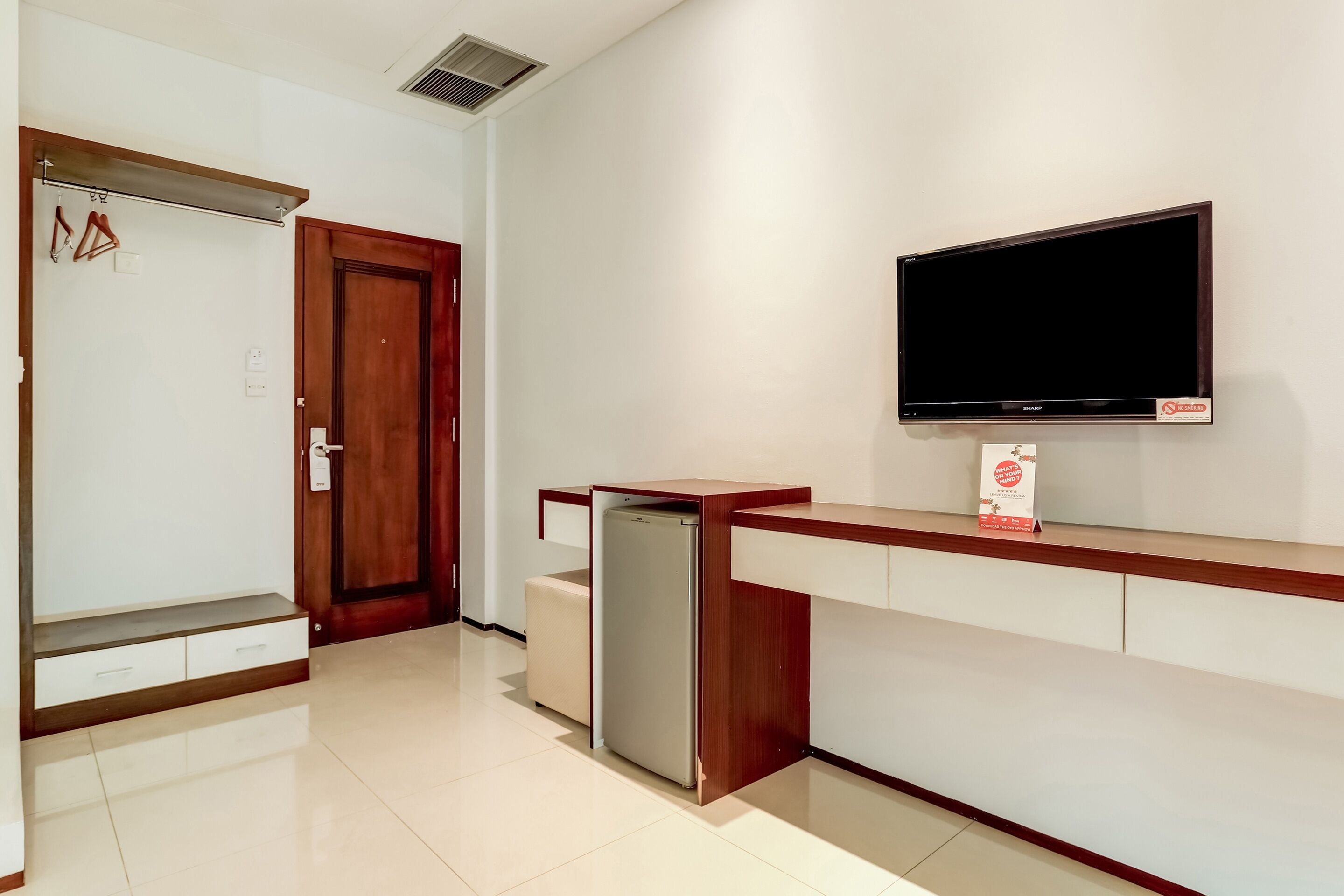 Una cocina moderna con refrigerador integrado, encimera de madera y televisor montado en la pared.