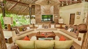 A cozy living area with a large sofa, a coffee table, and a television.