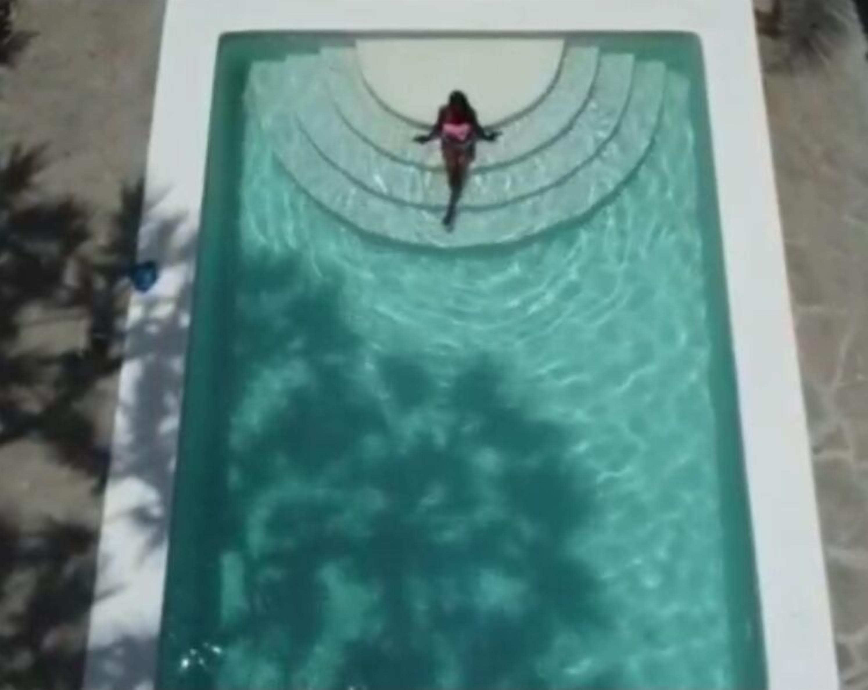 A rectangular pool with a person swimming.