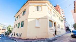 A corner building with a beige facade, multiple windows, and a visible fire hydrant. - LE FLORIDA AP4340 By Riviera Holiday Homes (Villefranche-sur-Mer)