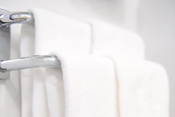 A white towel hanging on a metallic towel rack. - Business Hotel Mercury Royal Inn Group (Higashimurayama)