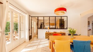 A bright dining area with a large table, chairs, and a modern chandelier. - Comfortable villa 10 minutes from the beach (La Garde)