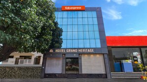Un edificio moderno con un letrero de 'fabexpress' y la señalización 'HOTEL GRAND HERITAGE'.