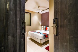 A bedroom with a bed, a ceiling fan, a window, and a door.
